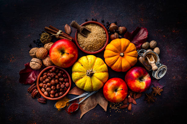 istock Autumn decorative pumpkins with apples, spices, nuts and fall leaves on dark background. Thanksgiving or Halloween holiday 1586062156