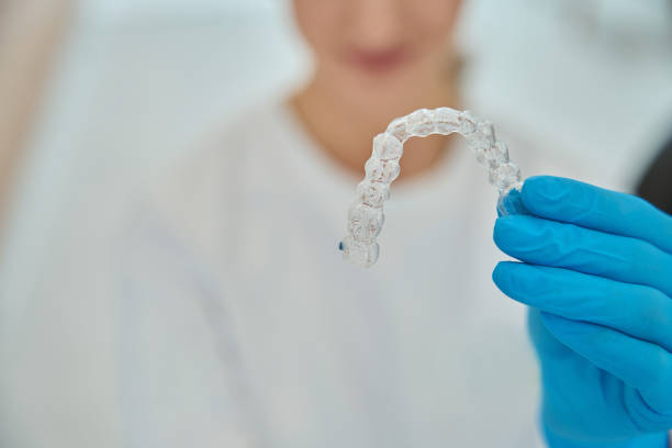 istock Stomatologist holding invisible removable aligners for teeth straightening 1586071983