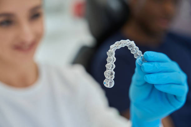 istock Dental technician holding invisible braces, or clear aligners 1586072441