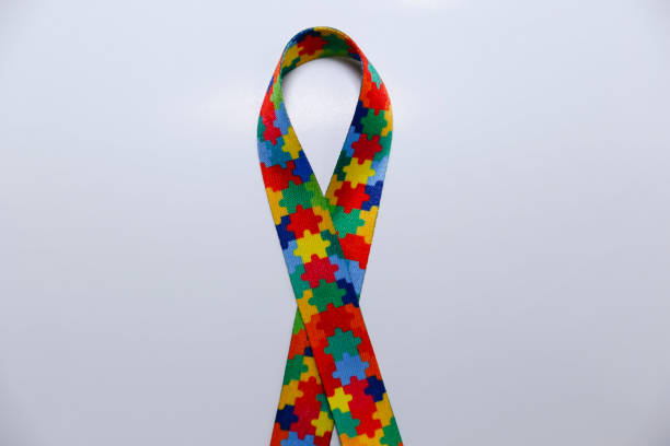 istock autism symbol - ribbon formed with colored puzzle pieces 1586076749