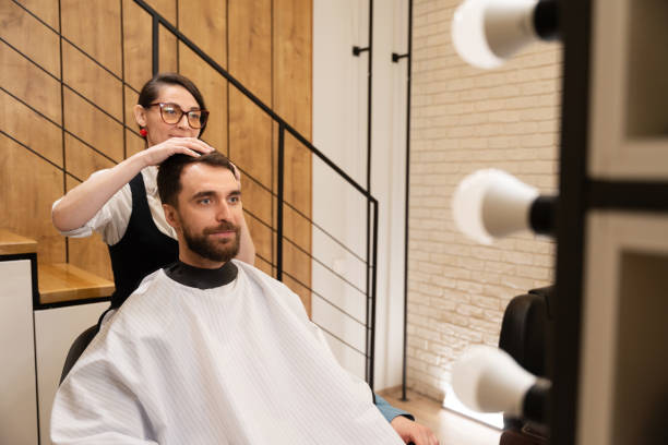 istock Cute barber is working with a client in modern barbershop 1586106941