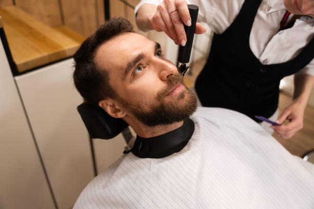 istock Barber cuts the beard and mustache to the client 1586149501