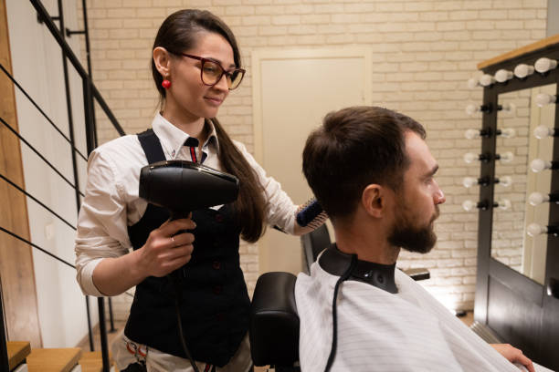 istock Young barber doing hair styling to a client 1586149545