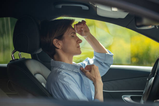 istock Tired middle aged woman feeling bad, having headache, nausea healthy problems driving car. 1586150072