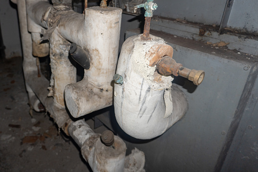Photo of pipe insulation containing asbestos fiber in a mechanical room in Florida USA.