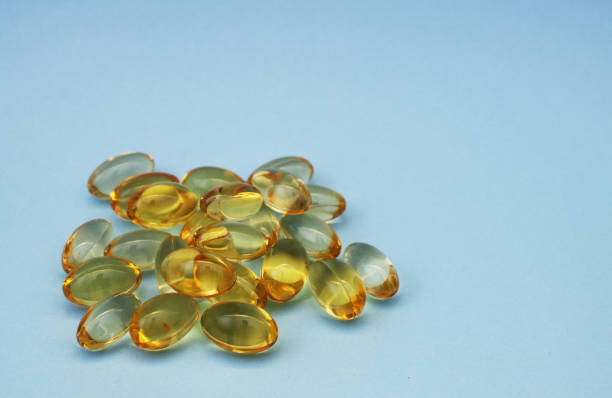 istock Fish oil capsules omega 3 on light blue background. 1586240311
