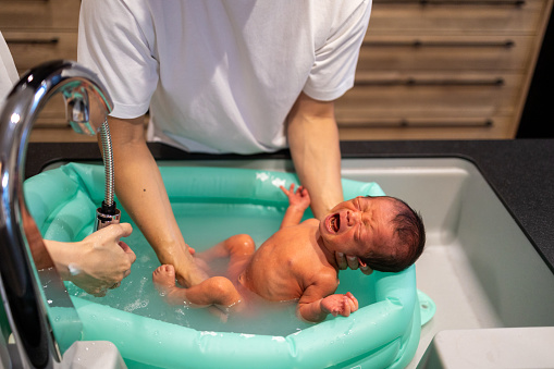 Father bathing his baby at home