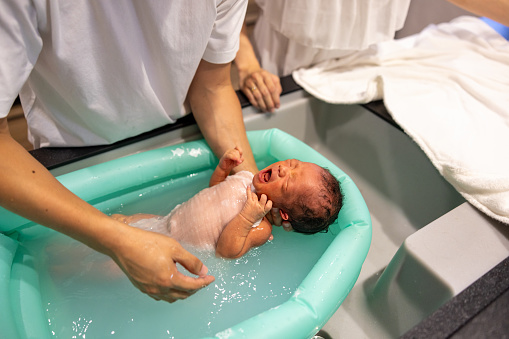 Father bathing his baby at home