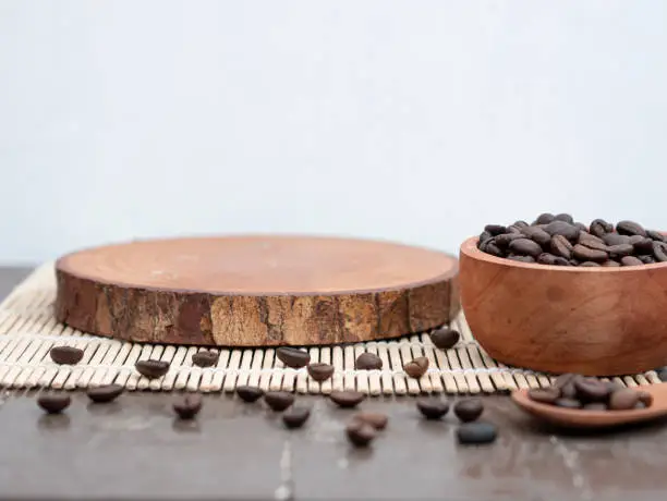 a round wooden plank and scattered coffee beans. product placement concept for coffee drinks.