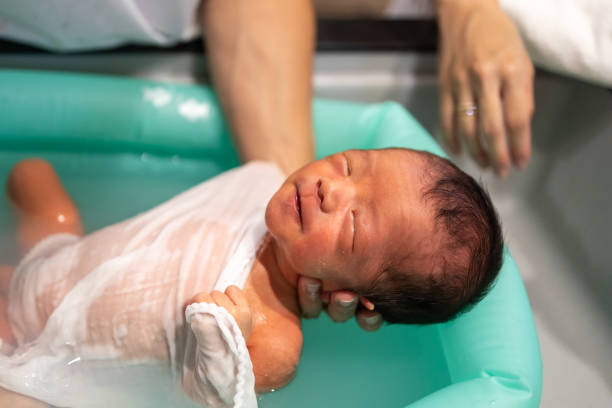 istock Father bathing his baby at home 1586242425