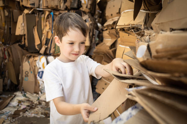 istock 6 year old boy learning to sort cardboard waste 1586257225