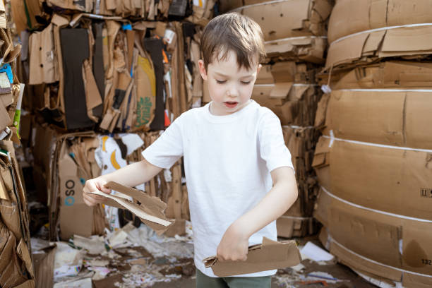 istock 6 year old boy learning to sort cardboard waste 1586264146