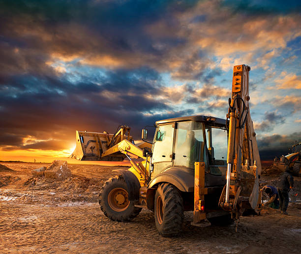 excavator at construction сайт - earth mover digging land bulldozer стоковые фото и изображения