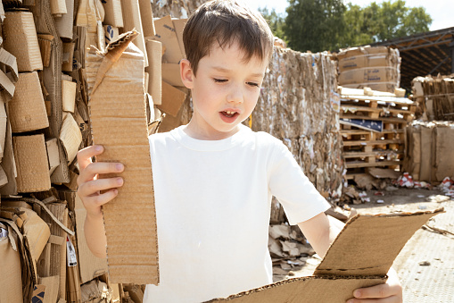 6 year old boy learning to sort cardboard waste