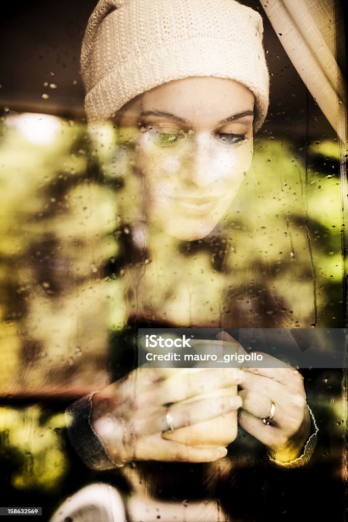 Pensativo mujer mirando a través de una ventana - Foto de stock de Día libre de derechos