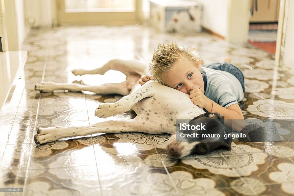 Young boy に横たわる彼の犬のフロアー - 床のロイヤリティフリーストックフォト