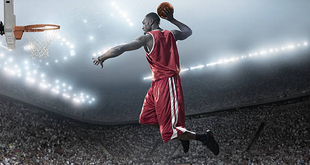 Basketball Player About To Slam Dunk basketball player in mid air about to score basket during professional basketball game in indoor arena slam dunk stock pictures, royalty-free photos & images