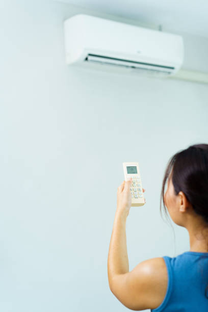 istock Woman turning on or off air conditioning. 1586421052