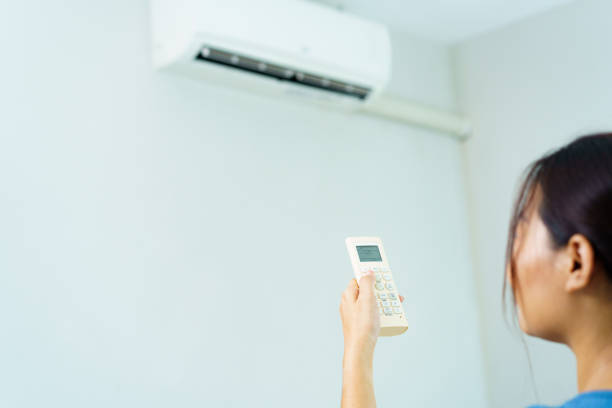 istock Woman turning on or off air conditioning. 1586421056