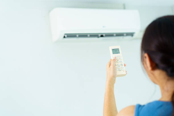 istock Woman turning on or off air conditioning. 1586421059