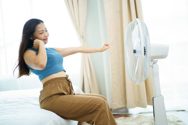 gemütliche frau mit einem elektrischen ventilator. - electric fan women wind beautiful stock-fotos und bilder