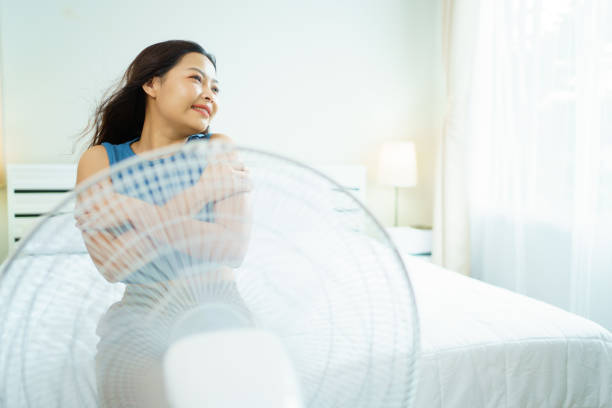 gemütliche frau mit einem elektrischen ventilator. - electric fan women wind beautiful stock-fotos und bilder