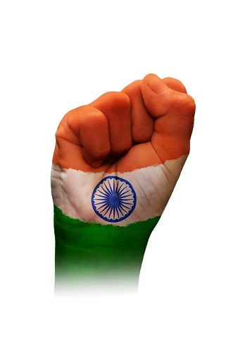 A horizontal cutout of a fist of hand painted in three vibrant colored bands in orange, white and green with blue wheel with spokes or Ashok Chakra in the middle. The image denotes confidence, strength and determination.There is no text and Copy space for text. Can be used for national festivals, events, national teams related backdrops like Indian Republic Day, Independence Day celebrations.