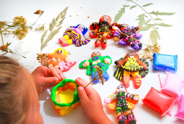 istock Child modeling from plasticine and clay, using nature materials,  sculpting, creating fairy tale with elves, angels, fairies. Imagination, inspiration, sensory perception, development with child 1586456266