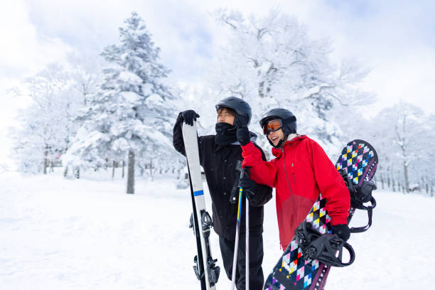 Asian couple practicing snowboard and ski together at snowy mountain on winter vacation Young Asian couple practicing freeride snowboard and ski on snowy mountain at ski resort. Man and woman enjoy outdoor activity active lifestyle winter extreme sport training on holiday travel vacation japanese snowboarder stock pictures, royalty-free photos & images
