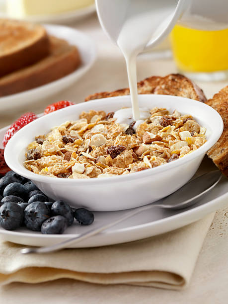 Almond and Raisin Breakfast Cereal Almond and Raisin Breakfast Cereal with Whole Grain Flakes, Fresh Fruit, Whole Grain Bread, Milk and Orange Juice- Photographed on Hasselblad H3D2-39mb Camera bran flakes stock pictures, royalty-free photos & images