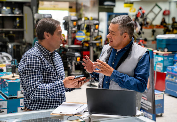 istock Customer asking advise to a retail clerk while buying tools at a hardware store 1586522931