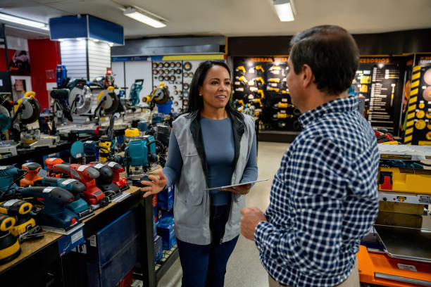 istock Saleswoman helping a man while shopping at a hardware store 1586523443