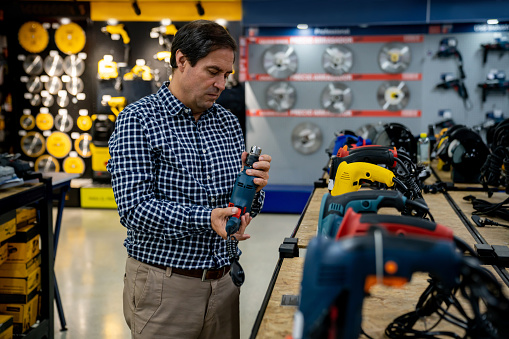 Latin American customer buying tools at a hardware store â small business concepts