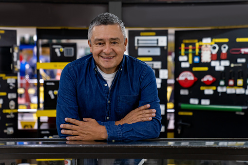 Portrait of a Latin American salesman working at a hardware store and looking at the camera smiling