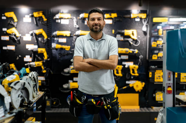 Portrait of a retail clerk working at a hardware store Portrait of a retail clerk working at a hardware store wearing a tool belt and looking at the camera smiling hardware store stock pictures, royalty-free photos & images