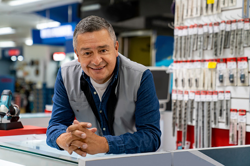 Portrait of a happy Latin American retail clerk working at a hardware store and looking at the camera smiling
