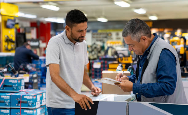 istock Delivery person picking up a package at a hardware store and asking for a signature 1586524529