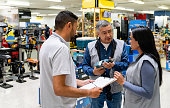 Business manager training two workers at a hardware store