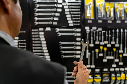 Close-up on a customer holding a wrench while shopping for tools at the hardware store