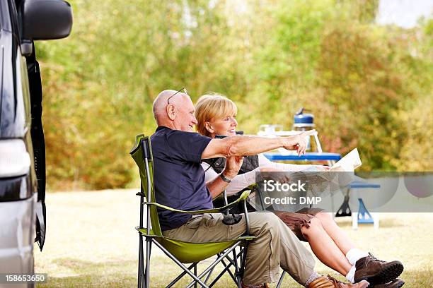 Senior Couple Sitting By Camper Van Reading A Map Stock Photo - Download Image Now - Motor Home, Senior Adult, Happiness