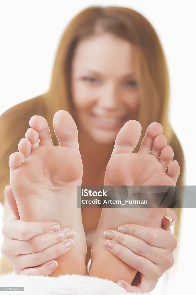 Chiropody Close-up woman applying moisturizer cosmetic cream on foot on light background Adult Stock Photo