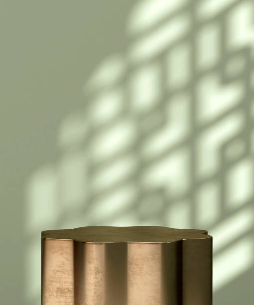 istock Smooth gold steel flower shape podium table in sunlight, Chinese window grill shadow on blank green wall 1586586706