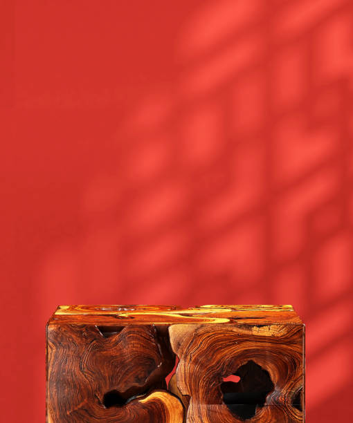 istock Brown natural log wood cube podium table in sunlight, Chinese round window grill shadow on blank vibrant red wall 1586586709
