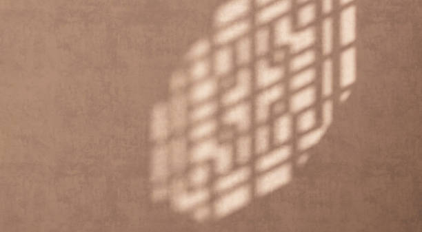 istock Sunlight and shadow of Chinese window grill on brown stucco texture wall with space 1586594055