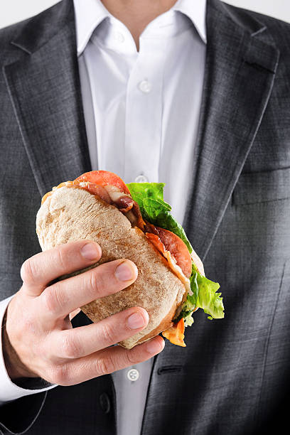 istock Man in suit holding lunch sandwich 158659477