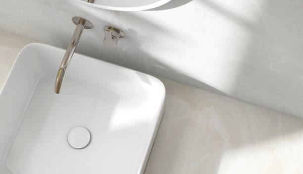 istock Cream marble vanity counter top, white modern rectangle ceramic washbasin, deck mount chrome faucet in bathroom in sunlight and shadow 1586618693