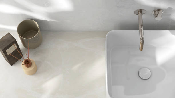 istock Reed stick diffuser, aroma oil, towel on cream stone vanity counter top in sunlight on white marble wall, wash basin 1586618695