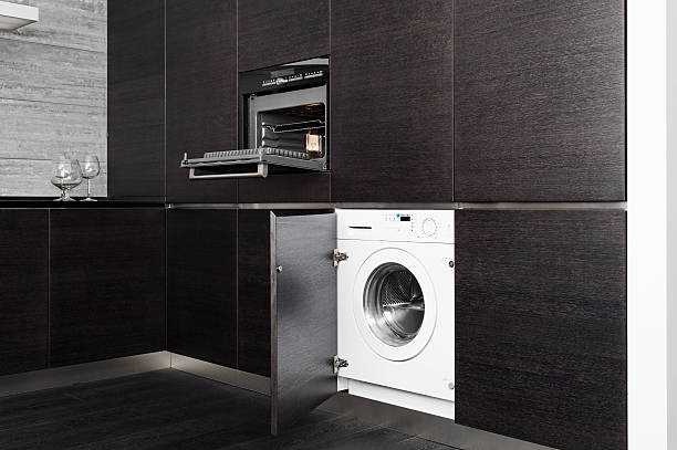 Build-in washing machine and cooker on modern black kitchen stock photo