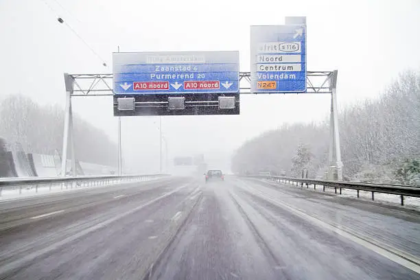 Driving in a snowstorm on the highway A10 near Amsterdam in the Netherlands