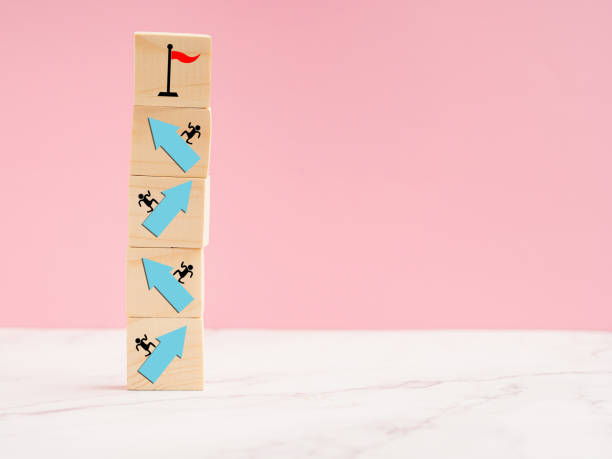 istock Wooden cubes with blue arrows up a point on a marble floor. 1586653710